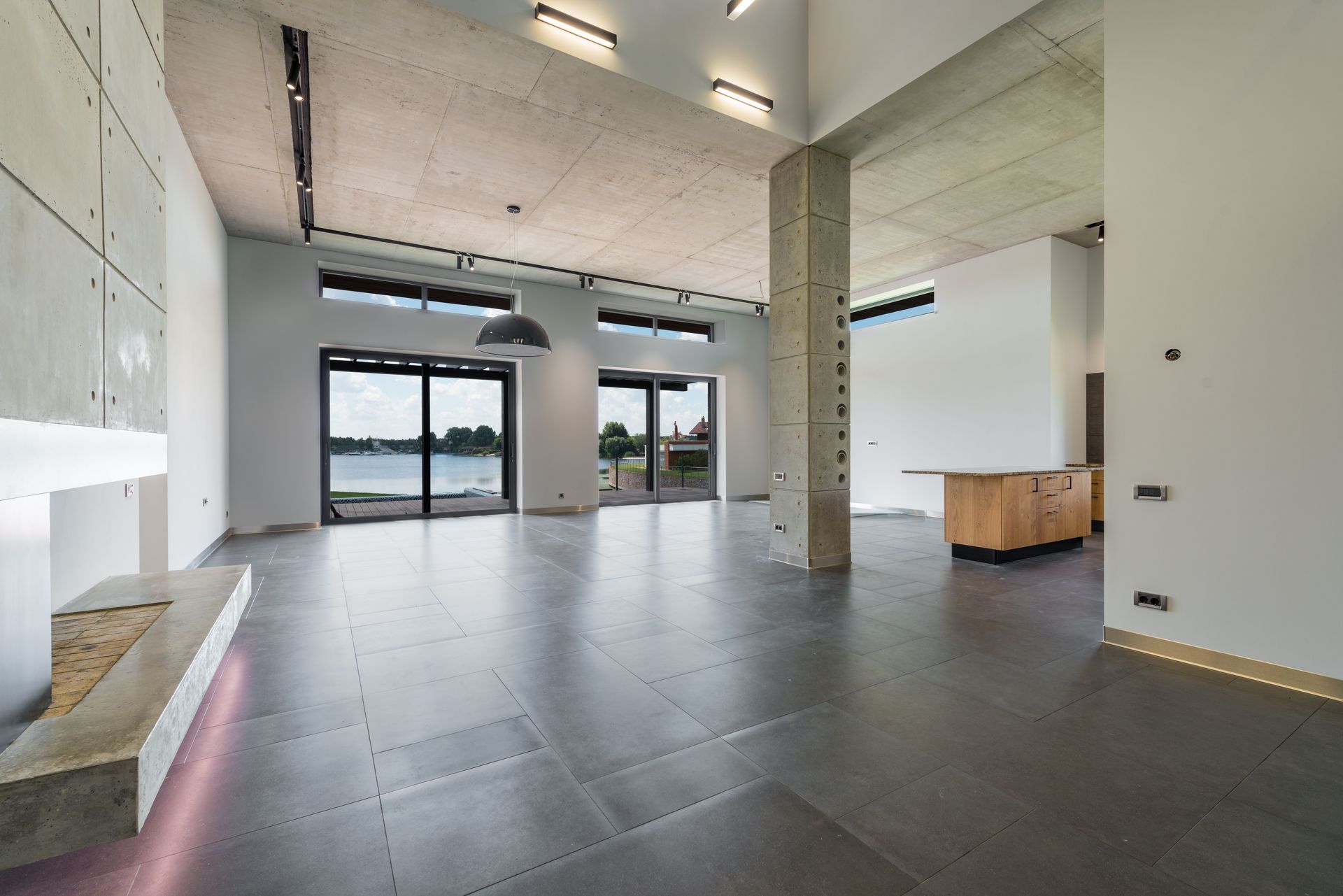 Interior of spacious new minimalist house with wooden furniture and panoramic windows with amazing lake view