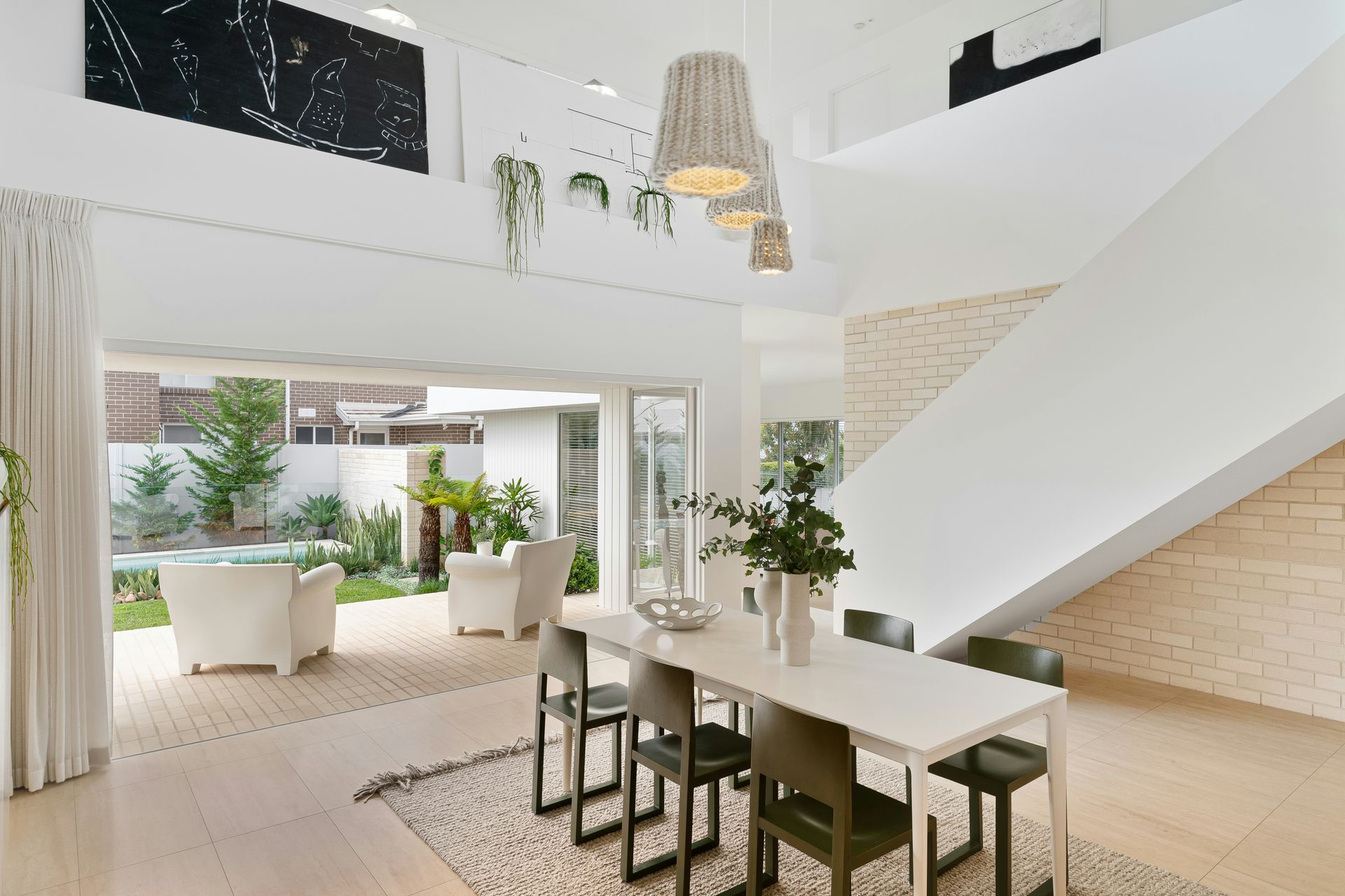 A dining room with a white table and chairs